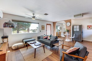 Ein modernes Wohnzimmer mit einer Couch, einem Couchtisch und einem Essbereich mit Stühlen und einem kleinen Tisch.