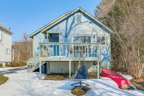A two-story house with a balcony, a slide, and a red canoe.