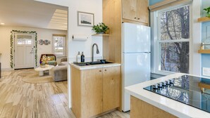 A modern kitchen with wooden cabinets, a built-in stove, and a refrigerator. - Lakefront Living By Mtn Creek! Modern Home w/ Deck (Sussex)