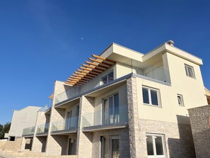 A modern multi-story building with balconies and large windows. - Apartment Mariner 2 With Heated Pool (Nin)