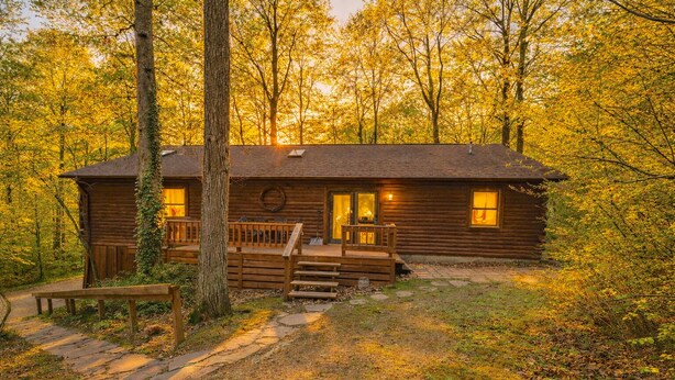 A rustic cabin with a porch, a front door, and a small window.