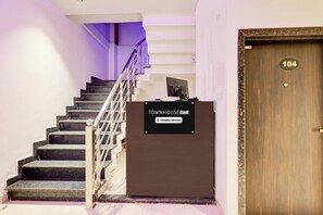 A staircase leading to a room with a sign reading 'Townhouse Oak' and a door labeled '104'.