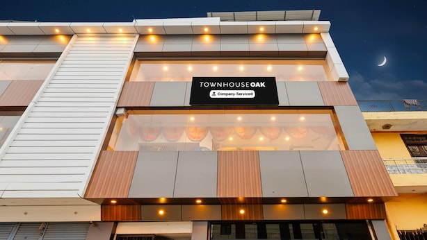 A modern building with a sign reading 'Townhouse Oak' and a company-serviced symbol. - Super Townhouse Oak Kanpur (Kanpur)