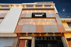 A modern building with a sign reading 'Townhouse Oak' and a company-serviced symbol.