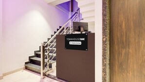 A staircase with a sign reading 'TOWNHOUSE OAK' and 'Company-Serviced.' - Super Townhouse Oak Kanpur (Kanpur)