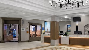 Un hall d'hôtel comprenant un comptoir d'accueil, un grand écran et une enseigne Club Wyndham.