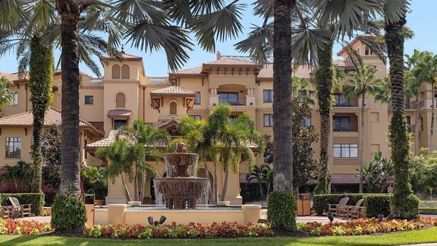 Un hôtel doté d’une fontaine centrale, de palmiers et d’un jardin bien entretenu.