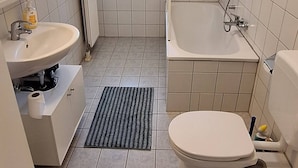 A bathroom with a toilet, bidet, sink, and a window. - Nice Apartment in the Center of Klöch (Kloech)