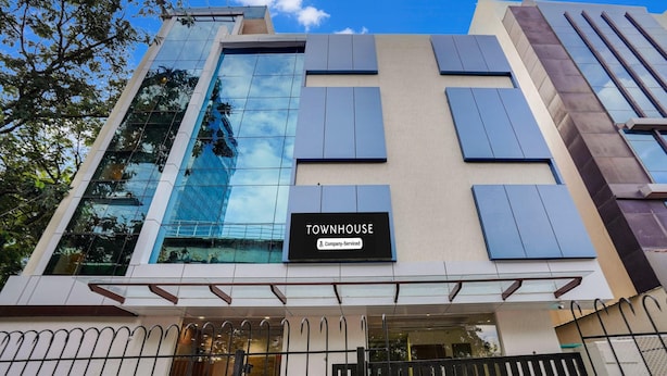 A modern building with a sign reading 'TOWNHOUSE' and a company-serviced symbol. - Super Townhouse Itpl Near Prestige Shanti Niketan (Bengaluru)