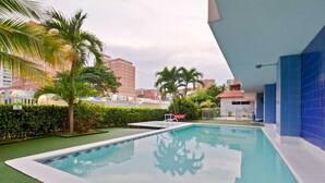 A swimming pool with a clear view of the surrounding buildings and greenery. - Altos del parque By Host Pro (Barranquilla)