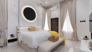 A modern bedroom with a bed, bedside table, and a wall-mounted circular light fixture.
