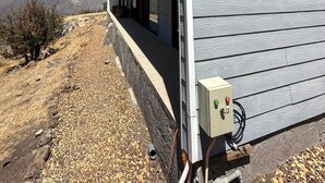 Un bâtiment moderne doté d’un toit en pente et d’un espace extérieur abrité.