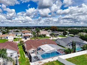 A residential area with houses, a swimming pool, and a clear sky. - Loma Vista Escape - 4BR Pool Home Near Disney, Golf & Shopping (Davenport)