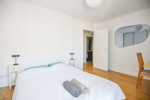 A bedroom with a bed, a chair, a nightstand, a mirror, and a wardrobe. - Le Bénédit - Appart 1 ch avec terrasse à Longchamp (Marseille)