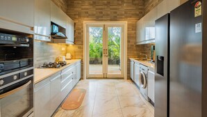 Una cocina moderna con horno empotrado, microondas y refrigerador de acero inoxidable.