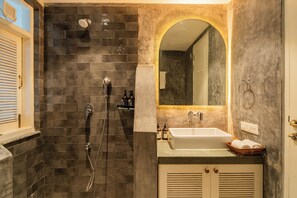A bathroom with a shower, sink, and mirror. - ELIVAAS Casa Ritzy 5 BHK Villa & Pool  (Calangute)
