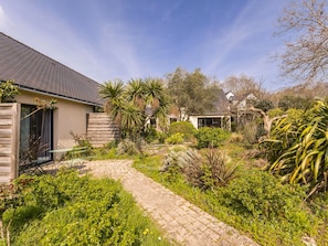 A residential property with a paved pathway, various shrubs, and a house with a sloped roof. - Room with private terrace - 2 guests (Guérande)