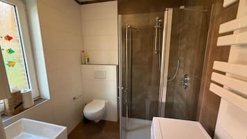 Een douche, een haardroger, zeep, toiletpapier