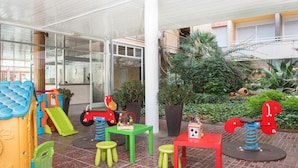 A children's play area with colorful play structures, seating, and potted plants. - Apartamento en Calafell Cerca de la Playa (Calafell)