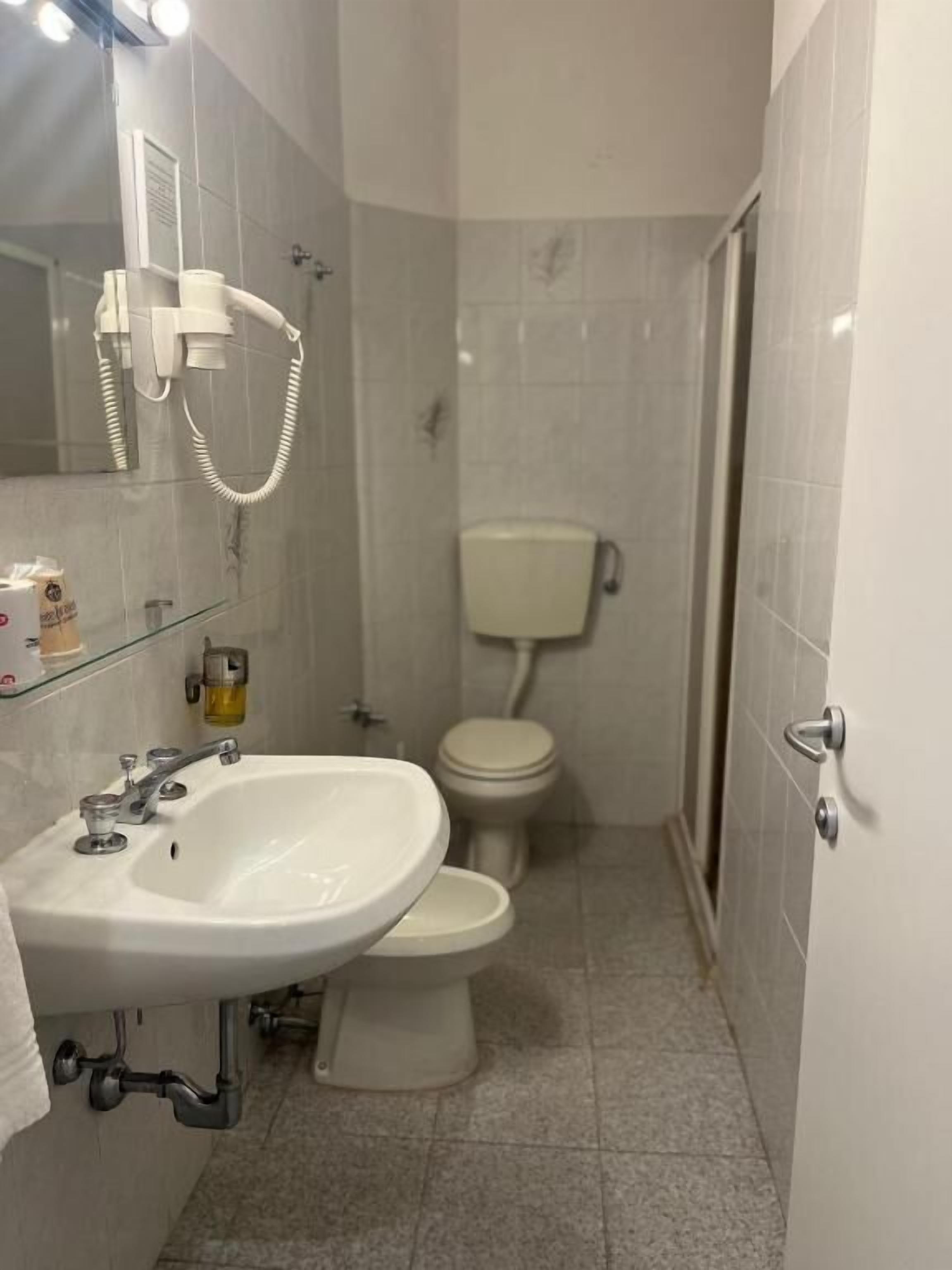 Ein Badezimmer mit Waschbecken, Toilette und Duschbereich.