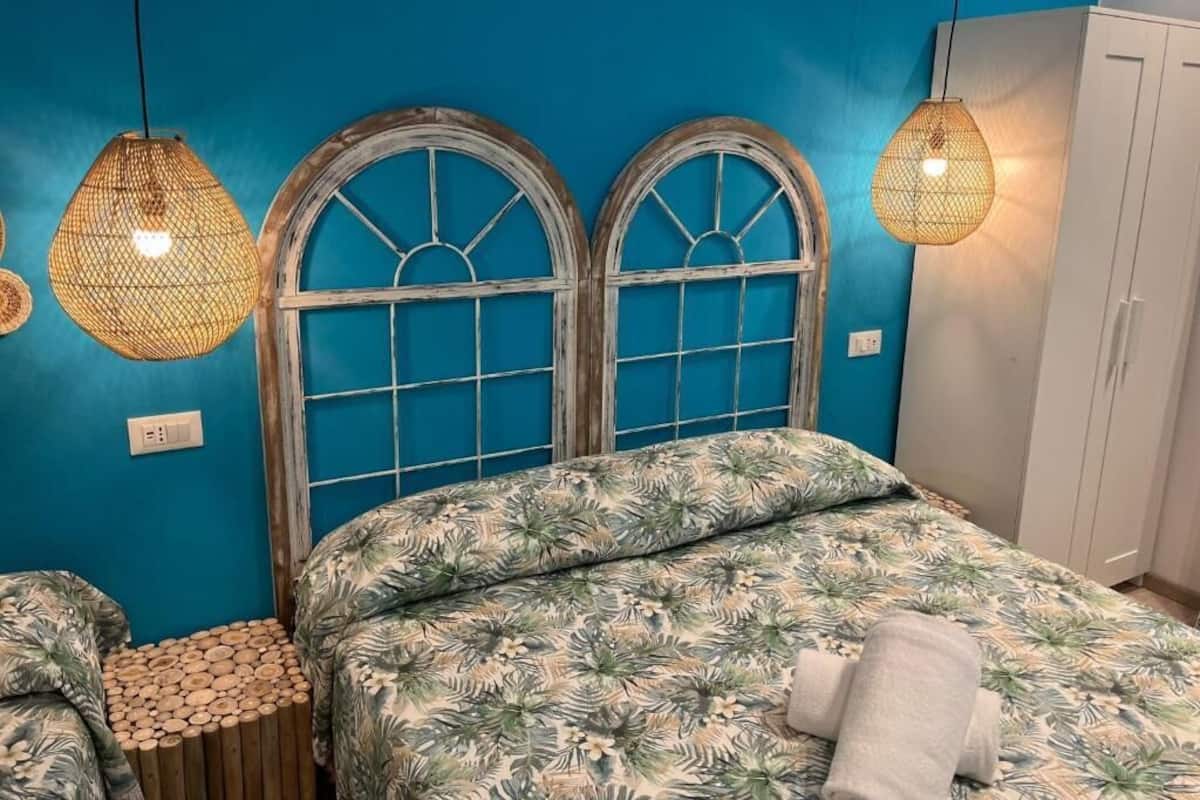 A room with a bed, a wardrobe, and a wall with a blue color scheme.