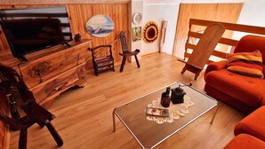 A cozy living room with a wooden floor, a television, a coffee table, a sofa, and a chair. - Central apartment, pets allowed - 6 guests (Saint-Michel-de-Chaillol)