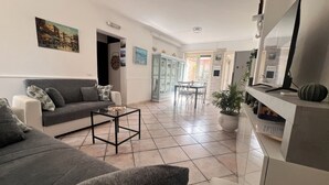 Ein Wohnzimmer mit einer Couch, einem Couchtisch und einem Essbereich mit Stühlen und einem Tisch.
