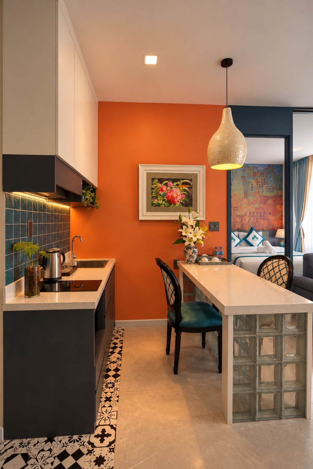 Una cocina moderna con una isla central, una zona de comedor con una silla y un cuadro en la pared.