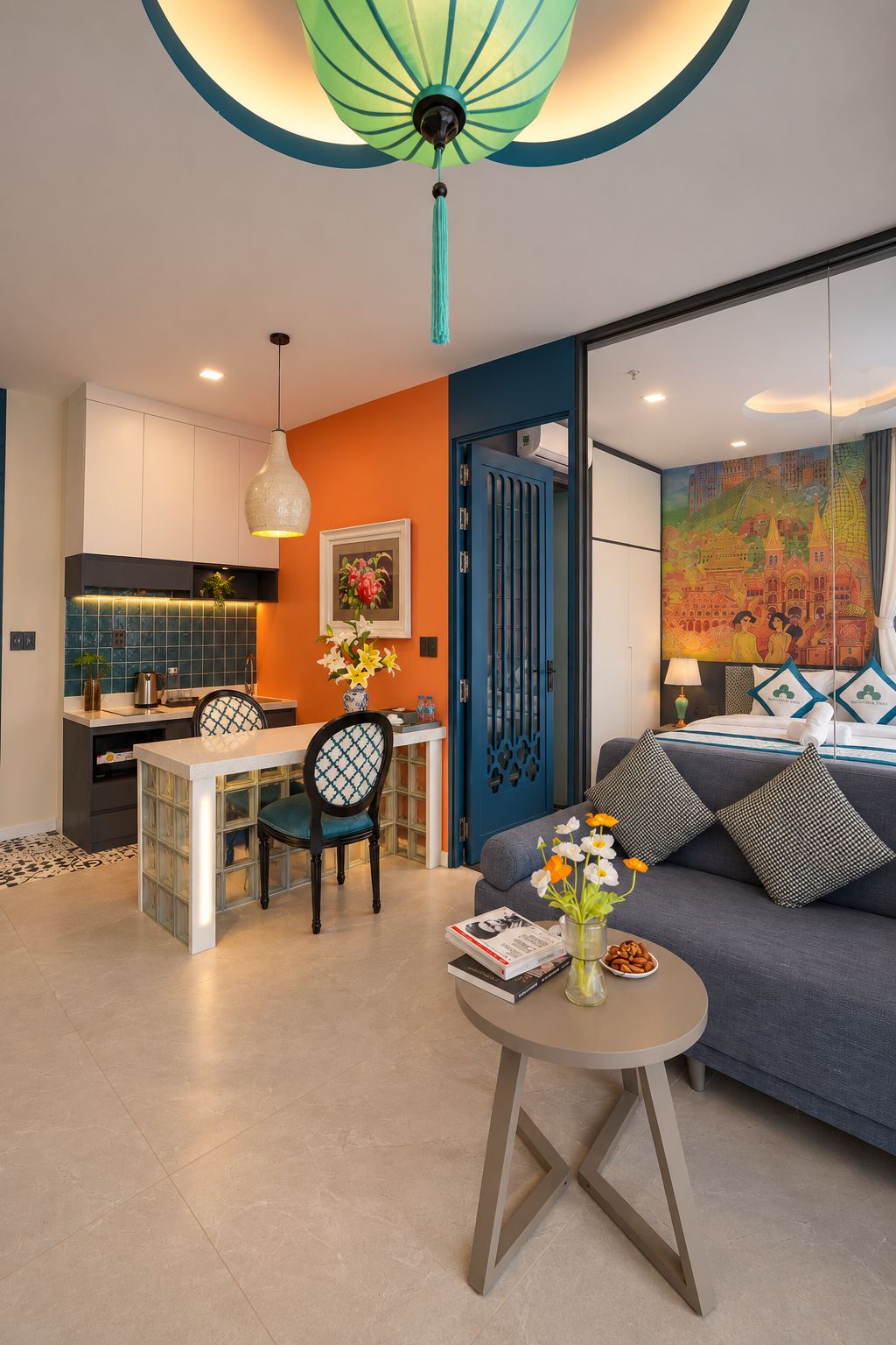 A modern living room with a sofa, a dining table, and a kitchen area.