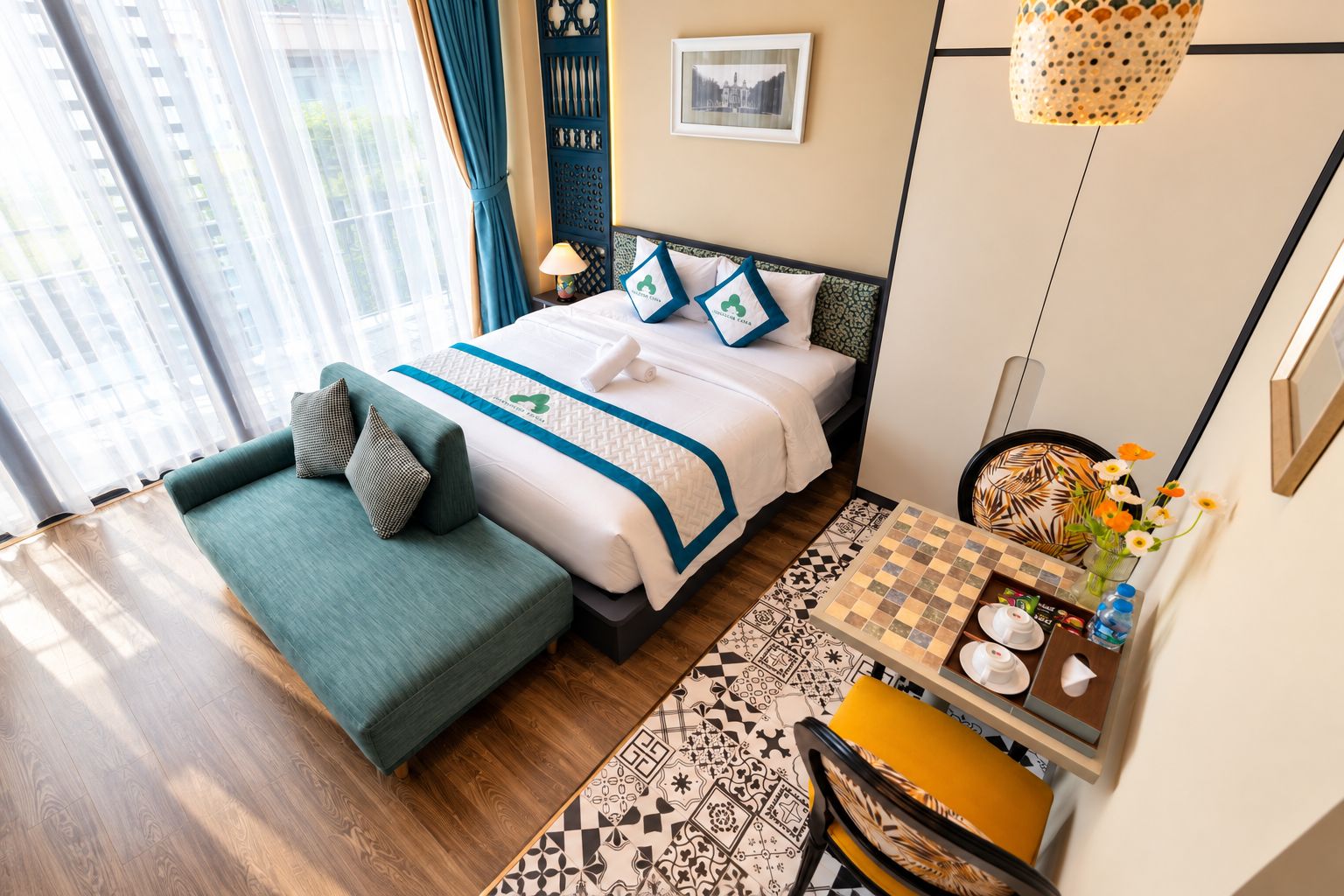 A hotel room with a bed, a sofa, a small table with a chessboard, and a chair.