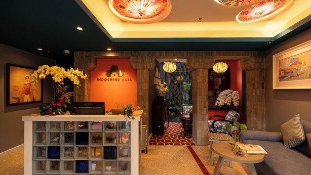 A reception area with a desk, a sofa, and a patterned floor. - Indochine Casa Hotel  (Ho Chi Minh City)