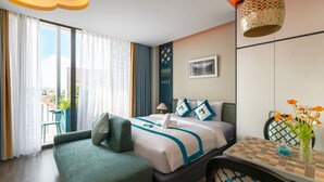 A hotel room with a bed, a sofa, a dining table, a view of the city, and a balcony. - Indochine Casa Hotel  (Ho Chi Minh City)