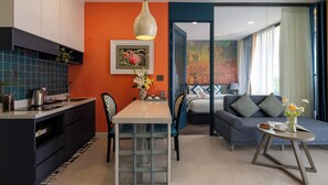 A modern living space with a kitchen, dining area, and a sofa set. - Indochine Casa Hotel  (Ho Chi Minh City)