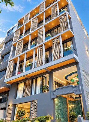 Ein mehrstöckiges Hotel mit Balkonen, modernem Design und einem gut beleuchteten Eingang.