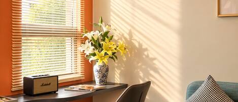 Una sala de estar moderna con un sofá, una mesa con un florero y un sillón.