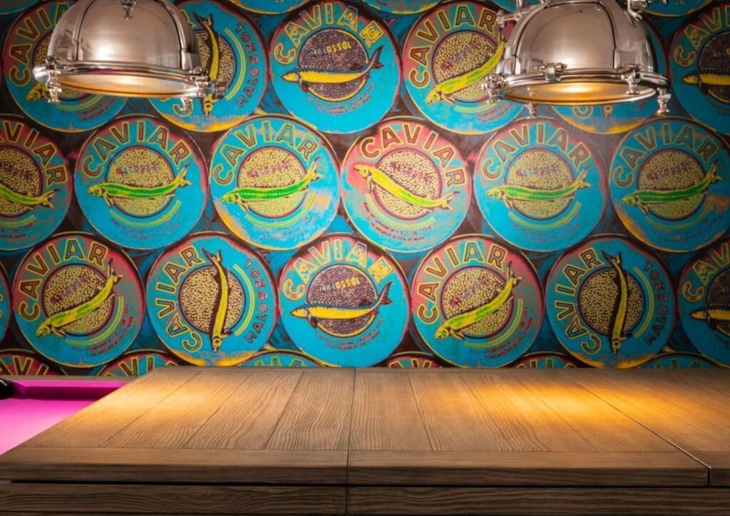 Una pared con diseños circulares y un piso de madera.