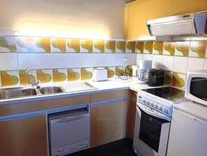 A compact kitchen with a sink, stove, microwave, and a toaster. - 200m from ski slopes, 1st floor, balcony, ski locker, 38m², Les Gets (Les Gets)