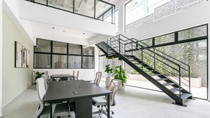 A modern office space with a conference table, chairs, a staircase, and large windows. - Pool plus 350MB Wi-Fi | 500m from the seafront #CA73D (Florianópolis)