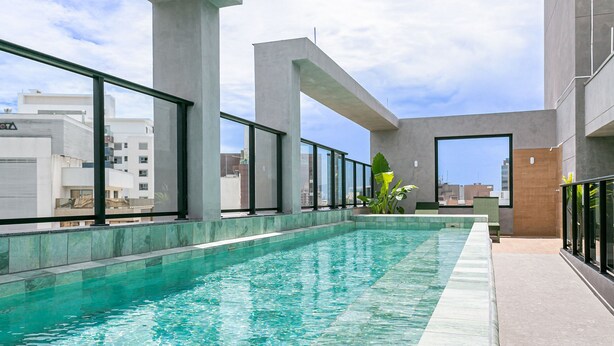 A rooftop swimming pool with clear water, surrounded by large windows and concrete pillars. - Pool plus 350MB Wi-Fi | 500m from the seafront #CA73D (Florianópolis)