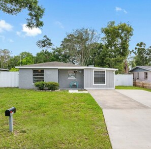 A single-story house with a front porch, a mailbox, and a small front yard. - Private Tampa Home w/ Basketball Court & Fire Pit - Near USF & Busch Gardens (Tampa)