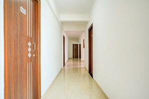 Un pasillo con una puerta de madera marcada '503' y suelo de mármol.