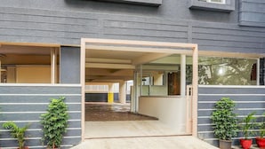A building entrance with a glass door, potted plants, and a tiled floor. - Deluxe Hebbal Townhouse (Bengaluru)
