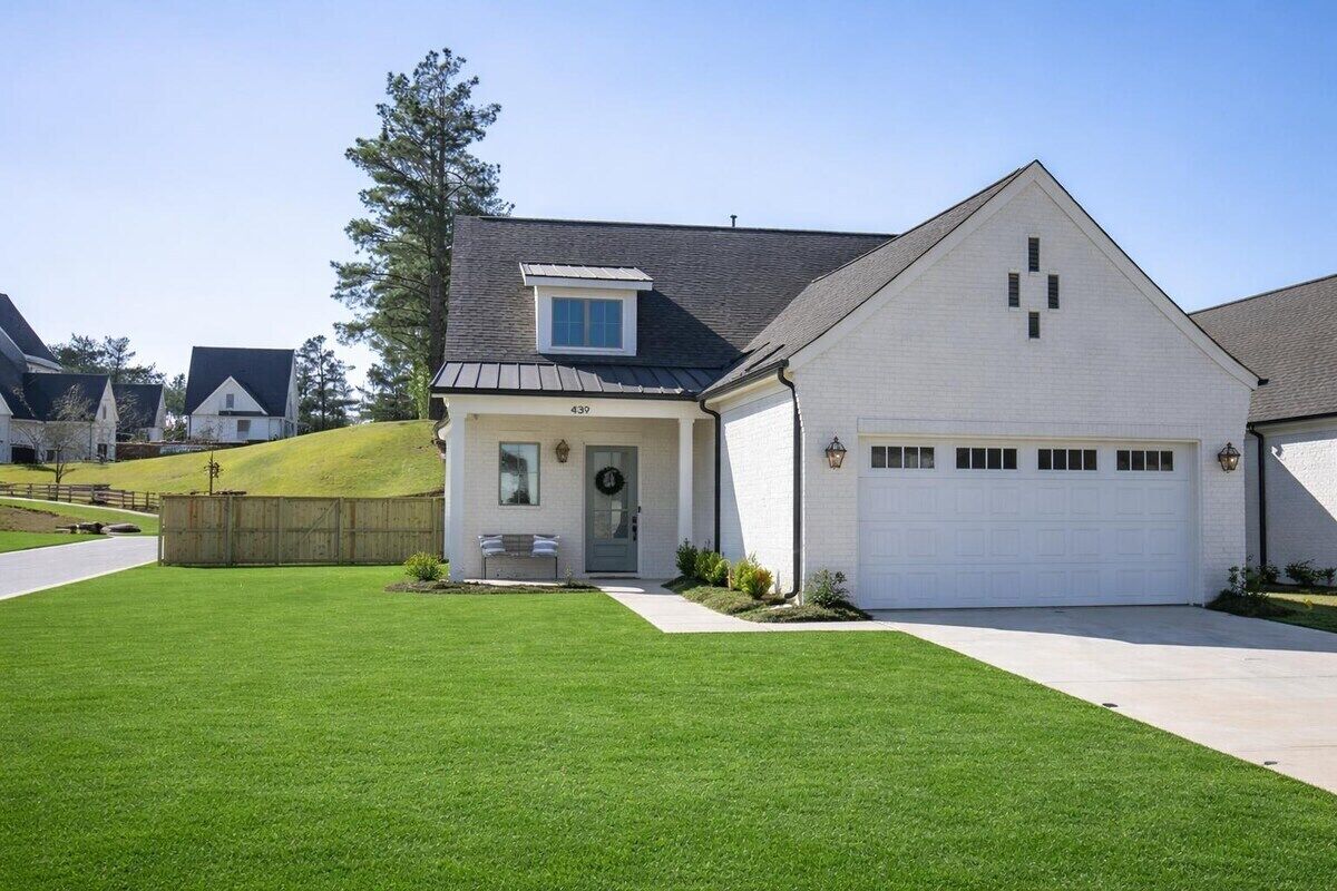 A single-story house with a garage, a small porch, and a well-maintained lawn.