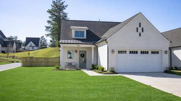 A single-story house with a garage, a small porch, and a well-maintained lawn.