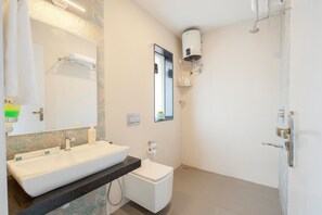 Ein modernes Badezimmer mit einem großen Waschbecken, Toilette und einer Dusche mit Wandheizung.
