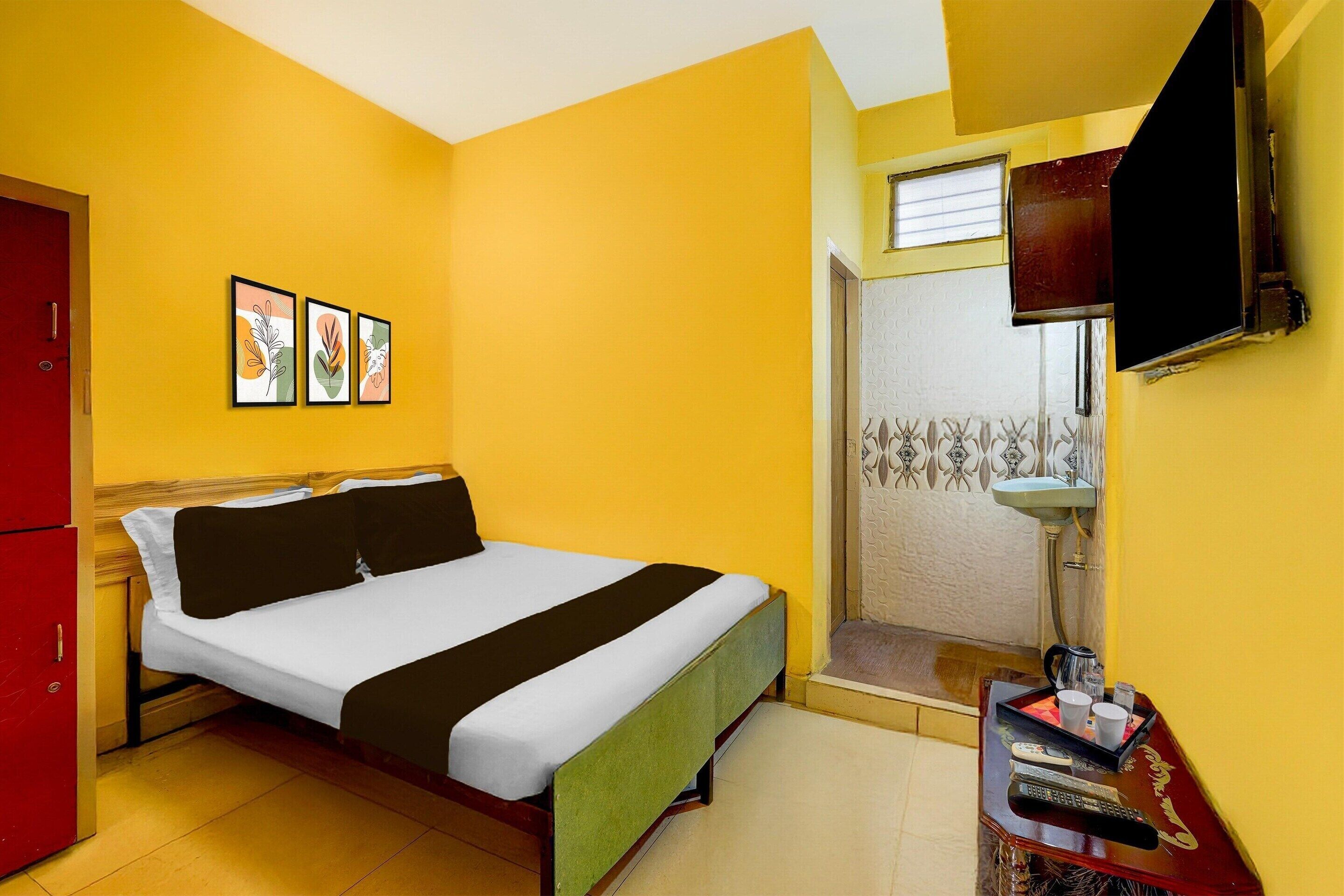 Una habitación con cama, televisión, ducha y una mesita con bandeja.