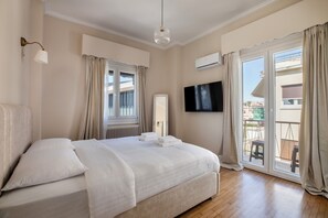 A bedroom with a bed, a TV, a window, and an air conditioning unit. - Acropolis Museum View Residence by A&A Residences (Athens)
