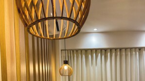 A hotel room with a wooden headboard, a hanging light fixture, and a view of the outside through sheer curtains. - Downtown Gramado-RS - With Free Parking - Vita Boulevard (Gramado)