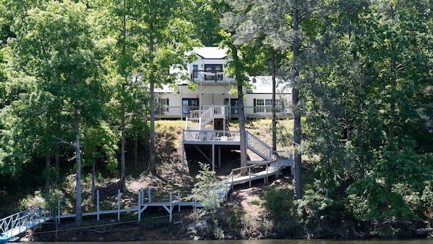 A lakeside property with a dock, a wooden deck, and a building with multiple levels. - Hot Tub! Hidden Kayak Cove -2 Masters, Kayaks, Fire pit, & Game Room (Jasper)
