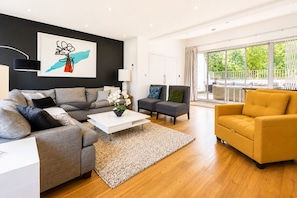 A modern living room with a grey sofa, a white coffee table, and a yellow armchair. - Modern 5BR Retreat with Private Roof Terrace & Garden by Hyde Park (London)